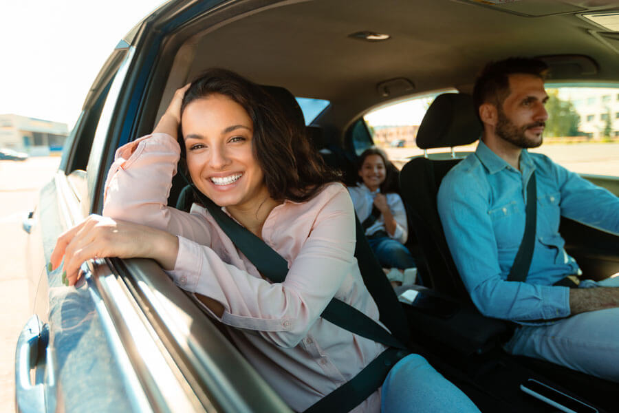 Happy family riding in a car, protected by auto and personal insurance services from Kange Insurance in Detroit.